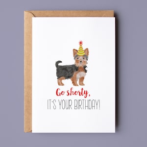 Pode incluir: Um cart&atilde;o de anivers&aacute;rio com uma ilustra&ccedil;&atilde;o em aquarela de um c&atilde;o pequeno usando um chap&eacute;u de festa. O texto no cart&atilde;o diz "Go shorty, it's your birthday!"