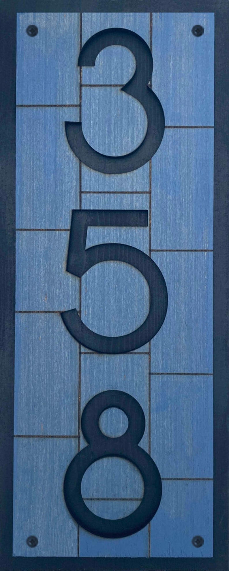 May include: A blue wooden sign with black numbers 358. The numbers are cut out of the wood and are raised.