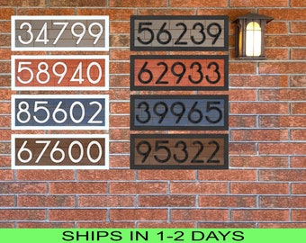 May include: Four sets of house numbers on a brick wall. The numbers are 34799, 58940, 85602, 67600, 56239, 62933, 39965, and 95322. The numbers are in black and white on a brown, red, blue, and gray background.