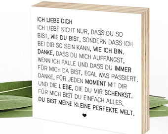 May include: A wooden block with a white background and black text that reads "Ich liebe dich. Ich liebe nicht nur, dass du so bist, wie du bist, sondern dass ich bei dir so sein kann, wie ich bin. Danke, dass du mich auffängst, wenn ich falle und dass du immer für mich da bist, egal was passiert. Danke, für jeden Moment mit dir und die Liebe, die du mir schenkst. Für mich bist du einfach alles. Du bist meine kleine perfekte Welt."