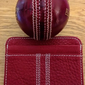 Tarjetero para tarjetas de crédito, billetes y billetes de viaje hecho a mano en cuero rojo con diseño de costura de pelota de críquet