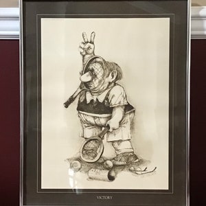 May include: A black and white illustration of a cartoon tennis player holding a tennis racket and making a peace sign. The player is surrounded by tennis balls and a can of tennis balls. The image is framed and has the word "VICTORY" printed below the image.