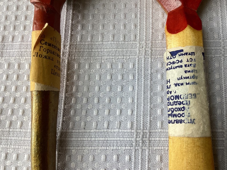 May include: Two wooden spoons with labels. The spoon on the left has a label that reads "Семенков Горьковская Ложка" and the spoon on the right has a label that reads "Управле тромы рхобл Предпр БЕЛОМОР г. Ар Марм. изд. Ле Артикул Цена H Вата выпуск РСТ РСФСР OTH Штамп".