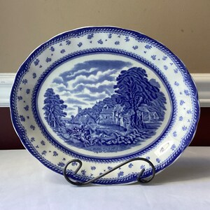 May include: A blue and white oval serving platter with a blue and white landscape scene and the text "Arnold Print & Cattle Co.  Ogden, Utah" in the center.