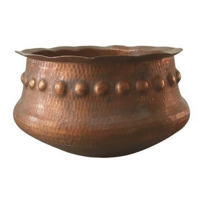 May include: A hammered copper bowl with a scalloped rim and a row of decorative rivets. The bowl has a rounded base and a textured surface, showcasing a warm, reddish-brown hue. This handcrafted piece is ideal for decorative use.