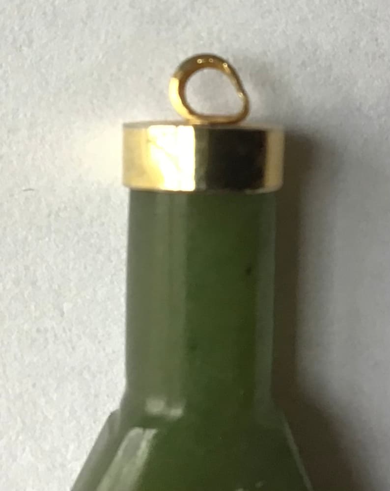 May include: A green jade pendant with a gold top and a gold loop for hanging.