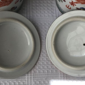 May include: Two white ceramic lids with a small hole in the center. The lids are plain white with no decorations.