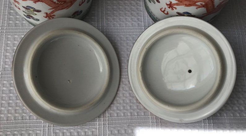 May include: Two white ceramic lids with a small hole in the center. The lids are plain white with no decorations.