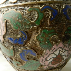 K&ouml;nnte beinhalten: Eine braune Keramikvase mit floralem Design. Die Vase ist mit gr&uuml;nem, blauem, rosa und wei&szlig;em Email verziert.