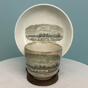 May include: A vintage teacup and saucer set with a black and white image of the Crystal Palace Exhibition of 1851. The text on the saucer reads "The Crystal Palace Exhibition 1851".