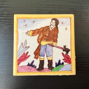 May include: A hand-painted ceramic tile featuring a whimsical illustration of a person in a brown jacket and blue pants holding a stick. The tile has a yellow border and a white background with colorful floral accents.
