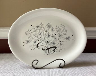May include: White oval platter with a black and gray floral design. The design features stylized flowers and leaves.