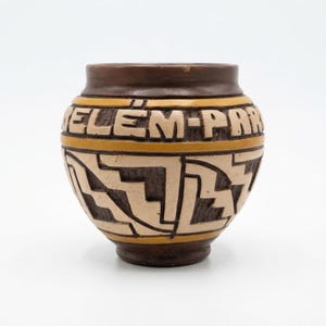 May include: A brown and cream ceramic vessel featuring a rounded body and a wide rim. The upper section displays the embossed text BELEM-PAR, while the lower portion is decorated with intricate, geometric, angular patterns in cream and brown.