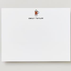 May include: White stationery card with a small illustration of a brown coffee pot with a blue handle and a green lid. The text "Emily Taylor" is printed in black below the illustration.