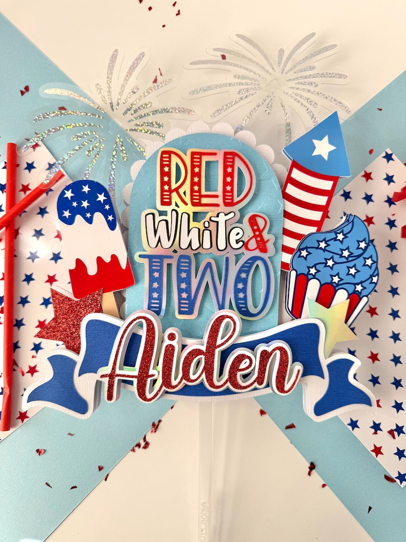 May include: Red, white, and blue cake topper with the words "Red White & Two Aiden" and a firework, cupcake, and popsicle design.