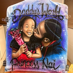 K&ouml;nnte beinhalten: Individuelle Jeansjacke mit Airbrush-Kunstwerk. Die Jacke zeigt ein Portr&auml;t eines Vaters, der seine Tochter k&uuml;sst, mit den Worten "Daddy's World" und "Princess Nai" in Schriftform. Der Hintergrund ist eine Mischung aus Blau und Lila mit Sternakzenten.
