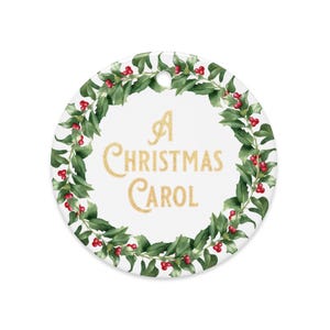 Puede incluir: Adorno navideño redondo y blanco con la inscripción dorada "A Christmas Carol". El texto está rodeado por una corona de hojas verdes y bayas rojas. Tiene un agujero en la parte superior para colgarlo.