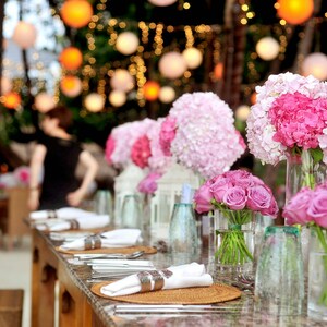 Peut inclure: Une table dress&eacute;e avec des fleurs roses et blanches dans des vases en verre. La table est dress&eacute;e avec des serviettes blanches, des couverts et des sets de table. Les fleurs sont dispos&eacute;es en diff&eacute;rentes tailles et formes, cr&eacute;ant une pi&egrave;ce ma&icirc;tresse magnifique et &eacute;l&eacute;gante.