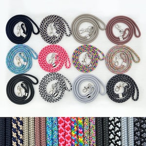 Könnte beinhalten: Zwölf verschiedene bunte geflochtene Lanyards mit silbernen Verschlüssen. Die Lanyards sind in drei Reihen mit jeweils vier Stück angeordnet. Die Lanyards bestehen aus verschiedenen Materialien, darunter Baumwolle, Nylon und Polyester.