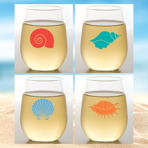 May include: Set of four clear glass wine glasses with different seashell designs. The glasses feature a red seashell, a turquoise seashell, a blue seashell, and an orange seashell.