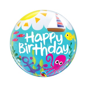 Può includere: Un palloncino a bolla blu e giallo con un sole, una barca a vela, un polpo e pesci. Il palloncino dice "Buon compleanno".