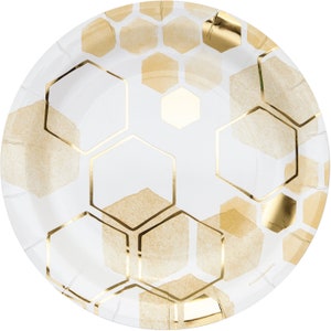 May include: White paper party plates with a gold honeycomb pattern. The plates are round and have a slightly raised edge.