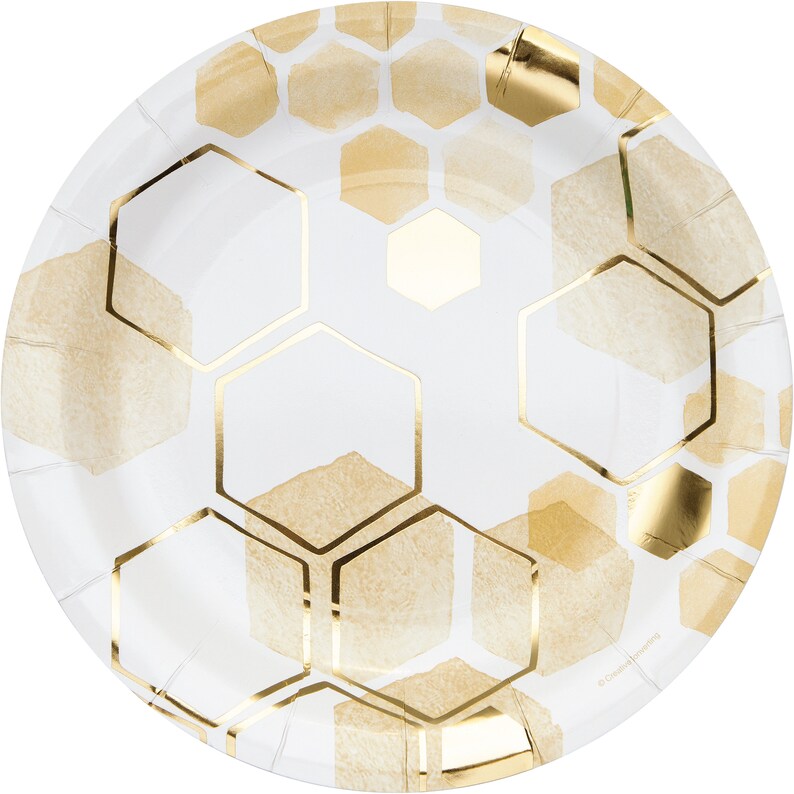 May include: White paper party plates with a gold honeycomb pattern. The plates are round and have a slightly raised edge.