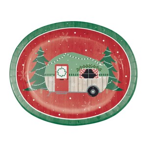 May include: An oval-shaped Christmas-themed plate with a red wood-grain background. A green camper with a wreath on the door and a string of lights is in the center. Two green Christmas trees flank the camper. The plate has a green border.