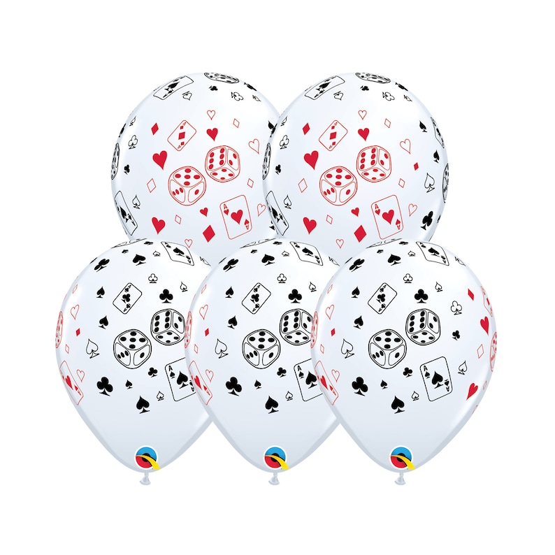May include: Five white balloons with a casino theme. The balloons are decorated with red and black playing card suits, dice, and playing cards. The balloons are inflated and ready for a party.