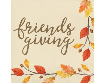May include: A square paper napkin with the words "friends giving" in brown script. The napkin has a cream background and is decorated with watercolor illustrations of fall leaves in shades of red, orange, and yellow.