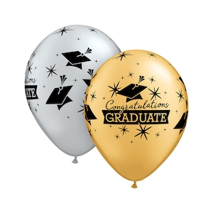 May include: Two graduation balloons, one gold and one silver, with black star and graduation cap designs. The gold balloon has the text "Congratulations GRADUATE" printed on it.
