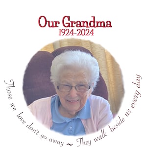 May include: A black and white photo of a woman in a blue shirt and pink sweater. The photo is in a circle with the text "Our Grandma 1924-2024" above the circle and the text "Those we love don't go away ~ They walk beside us every day" below the circle.