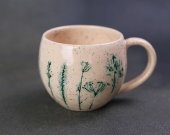 Delicate beige handmade ceramic mug with plant prints, handcrafted pottery coffee mug