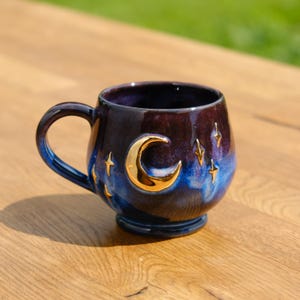 Handmade coffee cup stylized as a night sky with golden stars and moon, pottery Christmas gift mug