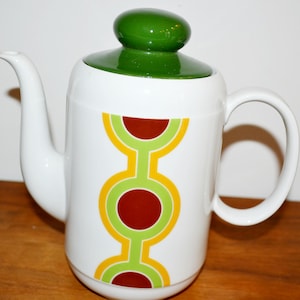 May include: White ceramic coffee pot with a green lid and a geometric design in yellow, green, and brown.