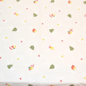 May include: White fabric with a repeating Christmas-themed pattern. The design includes green Christmas trees, red and yellow bells, red gift boxes, and red and yellow stars. White curved lines and small stars fill the background.