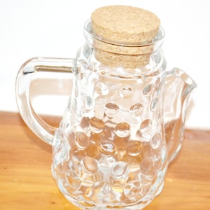 May include: A set of three ceramic mugs with a speckled, matte finish in cream, light grey, and dark grey. Each mug has a simple, minimalist design, suitable for coffee or tea.