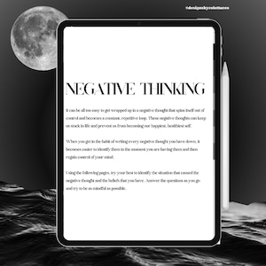 May include: A digital tablet with a white background and black text. The text reads "NEGATIVE THINKING" and includes a description of how to identify and manage negative thoughts. The tablet is on a dark background with a crescent moon visible in the top left corner.
