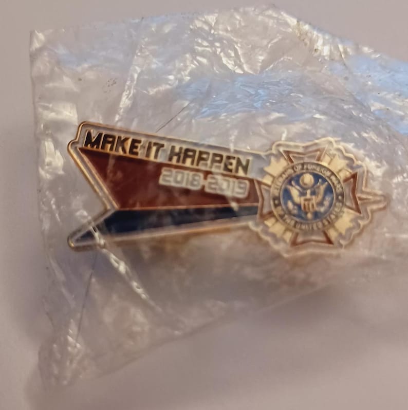 May include: Gold-colored pin with a red, white, and blue ribbon that says "MAKE IT HAPPEN 2018-2019". The pin also features a gold-colored star with a seal of the United States of America.
