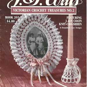 Puede incluir: Un marco de fotos de crochet blanco con una cinta rosa y una foto de dos mujeres montando en bicicleta. El marco está sobre una superficie rosa. El texto "J&P. Coats Victorian Crochet Treasures No. 2" está en la parte superior de la imagen. El texto "Book 202 $4.00" está en la esquina superior izquierda de la imagen. El texto "Featuring J. & P. Coats Knit-Cro-Sheen 16 Beautifully Easy Designs" está en la esquina superior derecha de la imagen.