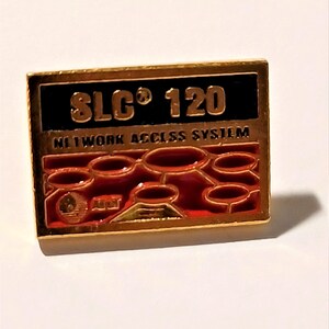 May include: Gold-colored pin with a black and red design. The pin features the text "SLC 120 NETWORK ACCESS SYSTEM".