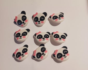May include: Ten white panda bear buttons with black eyes and pink cheeks. Each button has a pink bow on top of its head.