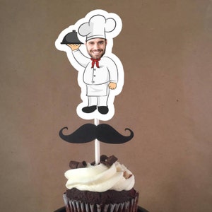 May include: A cupcake topped with white frosting and chocolate sprinkles, with a black mustache and a cartoon chef with a face cutout holding a serving tray on a stick.