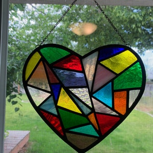 Turquoise blue stained glass heart sun catcher with poppies and butterflies.