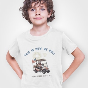 キッズTシャツ、おもしろアライグマシャツ、独立記念日ジョージア州ピーチツリーシティのゴルフカート「This is How We Roll」、幼児用サマートップス、子供用グラフィックTシャツ