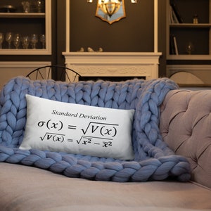 May include: A rectangular white throw pillow featuring the black printed text Standard Deviation and the mathematical formulas sigma of x equals the square root of V of x and the square root of V of x equals the square root of x squared minus x bar squared.