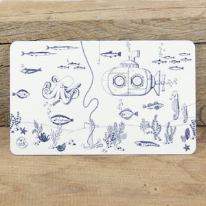 May include: A white placemat with a blue and white illustration of a submarine, an octopus, fish, and seaweed. The placemat has the text "Bow & Co." in the bottom left corner.