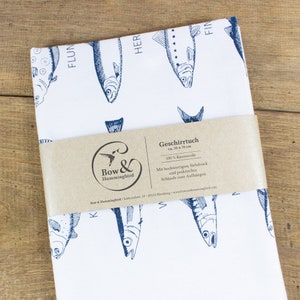 May include: White tea towel with a blue fish pattern and the text "Bow & Hummingbird" and "Geschirrtuch ca. 50 x 70 cm 100% Baumwolle Mit hochwertigem Siebdruck und praktischer Schlaufe zum Aufh&auml;ngen".