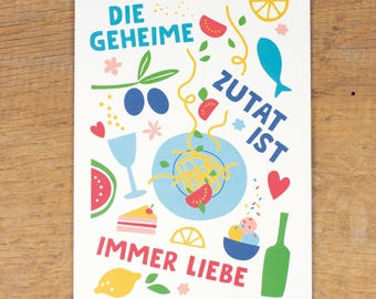May include: A white card with colorful illustrations of food and hearts. The text on the card reads "Die geheime Zutat ist immer Liebe".