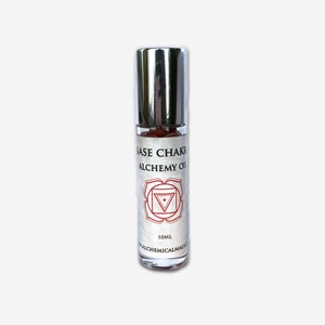 May include: A glass roller bottle with a silver cap and a white label. The label says "Base Chakra Alchemy Oil" and features a red chakra symbol. The bottle contains 10 ml of oil.